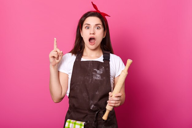 Foto interior de dona de casa criativa ocupada posando com equipamento de cozinha em uma mão