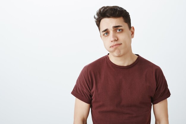 Foto interna de um homem bonito indiferente e impressionado com uma expressão sombria