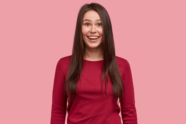 Foto interna de uma mulher bonita e sorridente com cabelo escuro que expressa sentimentos positivos