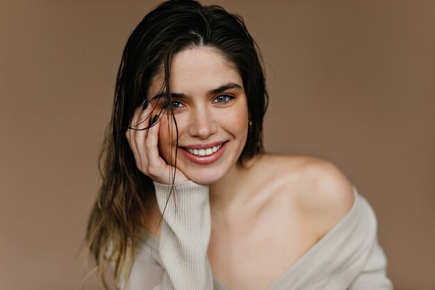 Foto interna de uma mulher branca fascinante. Menina na moda posando com um sorriso sincero.