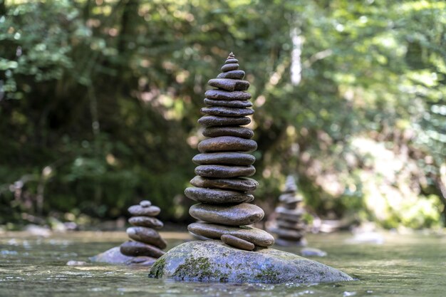 Foto majestosa de várias pirâmides de pedra equilibradas na água de um rio