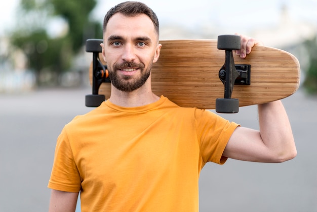 Foto média de homem segurando um skate