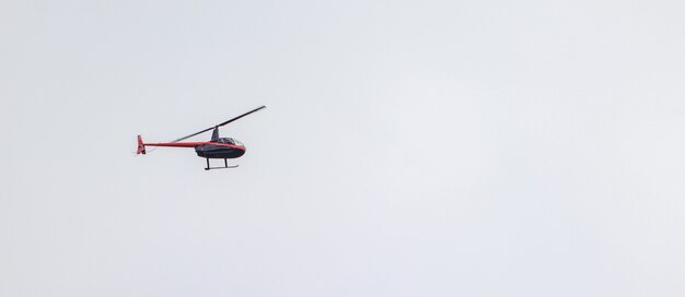 Foto panorâmica de um helicóptero voando em um céu nublado