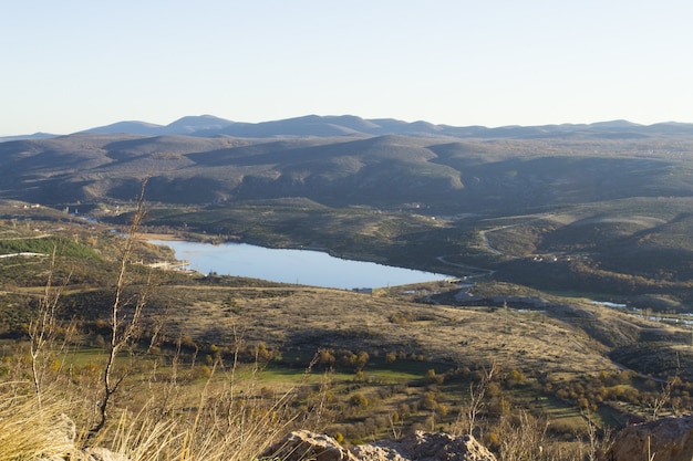 Foto panorâmica de um lago entre colinas sob um céu nublado