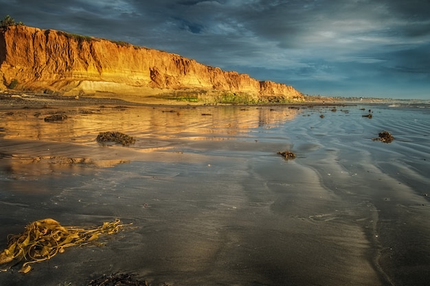 Foto panorâmica de um lindo penhasco na maré baixa sob um céu azul nublado