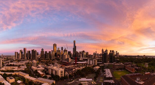 Foto panorâmica de uma paisagem urbana sob o lindo céu laranja durante o pôr do sol