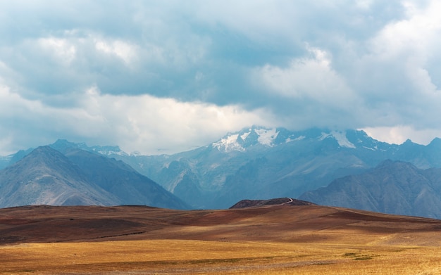 Foto panorâmica de uma planície com montanhas tocando o céu