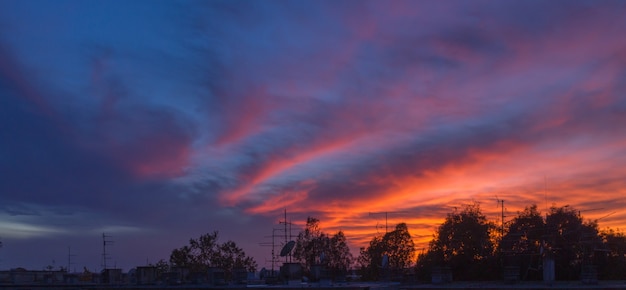 Foto panorâmica do pôr do sol em novo zagreb com silhuetas de antena de um prédio antigo