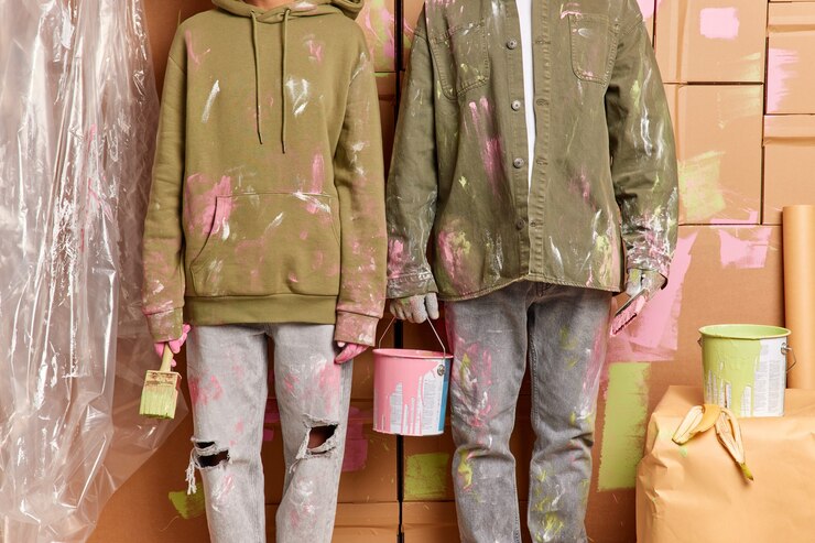 Foto grátis foto recortada de mulher e homem sujos trabalham como equipe segura escovas de balde de tinta pintando a casa após a relocação vestir roupas casuais imrpove apartamento. reforma em casa. trabalho em equipe e conceito de renovação