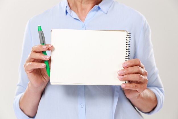 Foto recortada de mulher em roupas casuais, segurando o caderno isolado