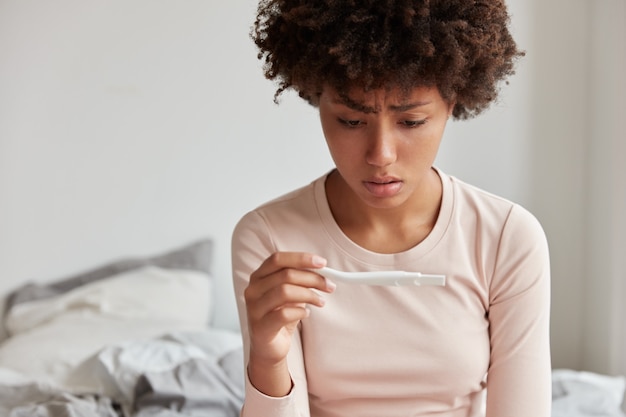 Foto grátis foto recortada de mulher estressante olhando para teste de gravidez