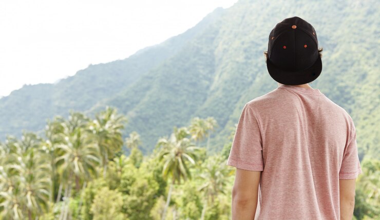 Foto grátis foto traseira de um jovem viajante caucasiano usando snapback se sentindo livre e em paz durante sua jornada nas férias de verão