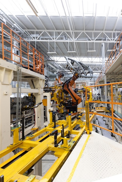 Foto vertical da linha de produção de automóveis Soldagem do corpo do carro Fábrica de montagem de automóveis moderna Indústria automobilística