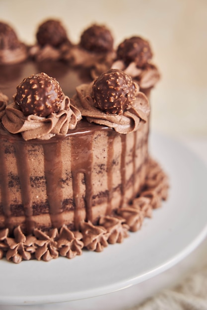 Foto vertical de alto ângulo de um bolo de chocolate fresco decorado com um delicioso chocolate em um prato