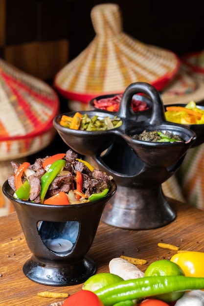 Foto vertical de deliciosa comida etíope com legumes frescos em uma mesa de madeira