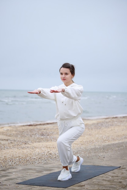 Foto vertical de jovem fazendo seus exercícios no tapete Foto de alta qualidade