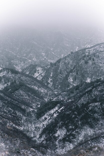 Foto vertical de montanhas cobertas de neve branca durante o inverno