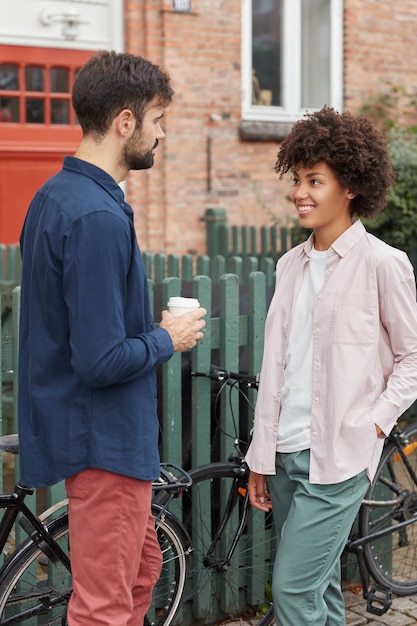 Foto vertical de mulher e homem inter-raciais opostos um ao outro