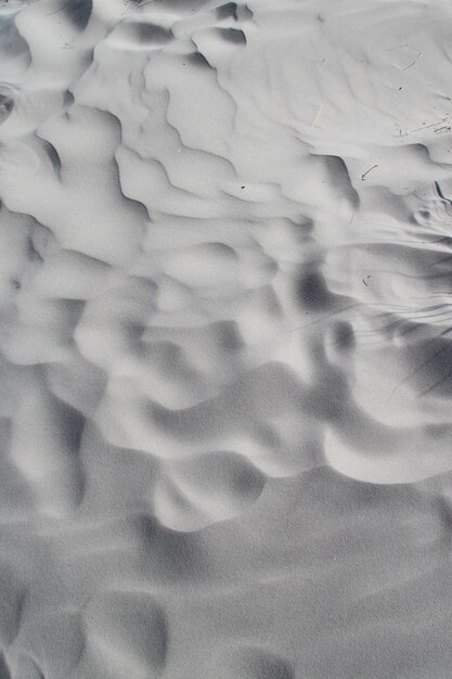 Foto vertical de ondas aleatórias na areia