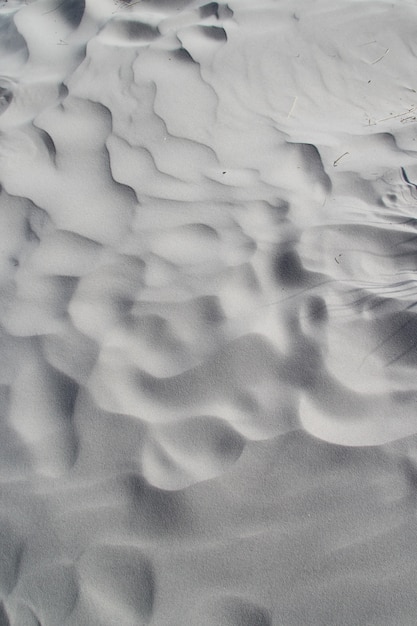 Foto vertical de ondas aleatórias na areia