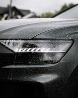 Foto grátis foto vertical de sabonete em um carro preto moderno e brilhante durante o dia