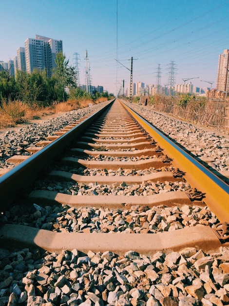 Foto grátis foto vertical de trilhos de ferrovia com edifícios