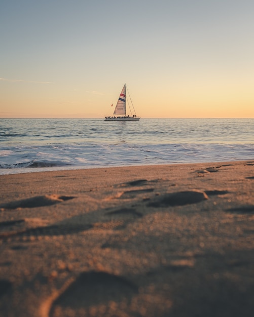 Foto vertical de um barco no mar à distância