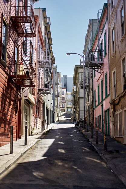 Foto vertical de um beco entre prédios de apartamentos em San Francisco, Califórnia, em um dia ensolarado