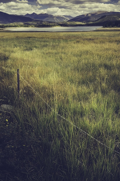 Foto grátis foto vertical de um campo com um lago cercado por montanhas no meio