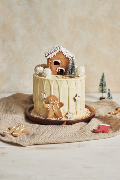 Foto vertical de um delicioso bolo de Natal com decorações de pão de gengibre e bolas de amêndoa de coco