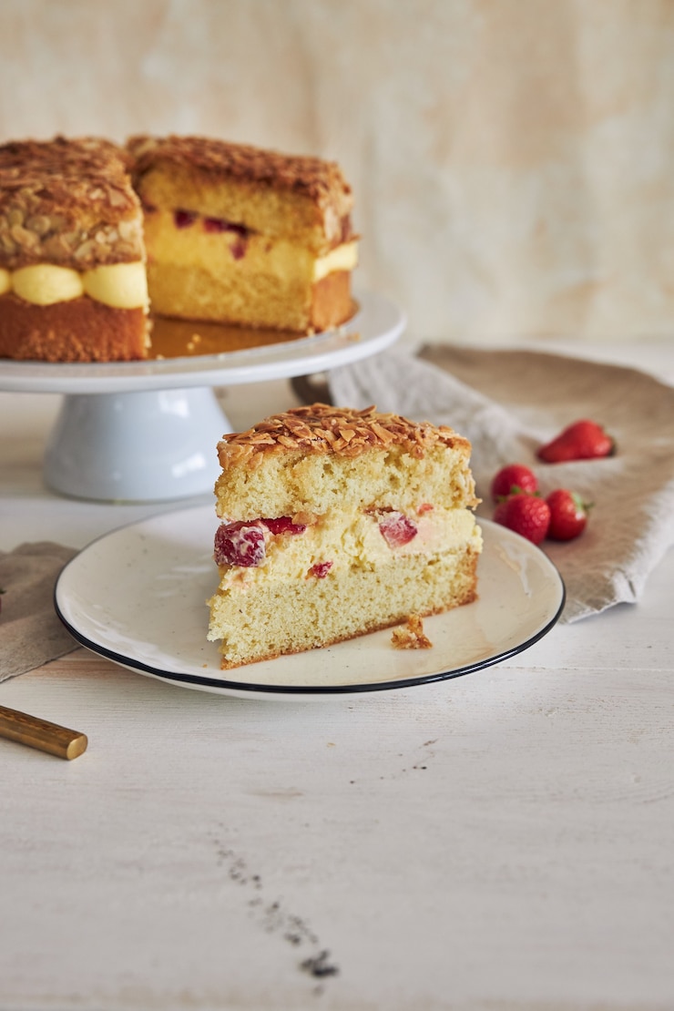 Foto grátis foto vertical de um delicioso pedaço de torta de creme com amêndoas crocantes e morangos