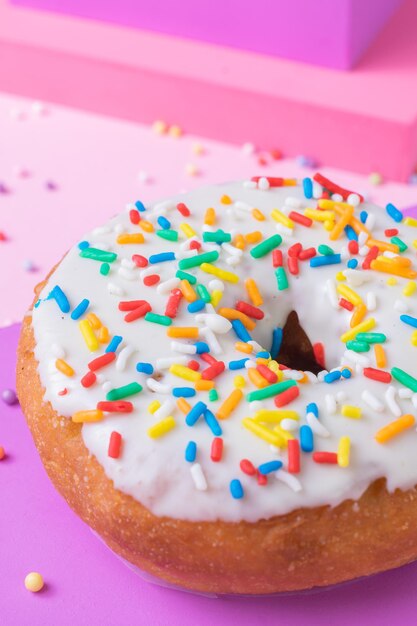 Foto vertical de um donut coberto com granulados coloridos