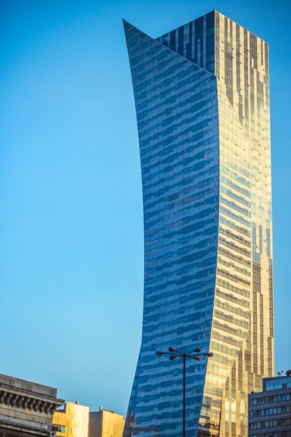 Foto vertical de um grande arranha-céu sob o céu azul