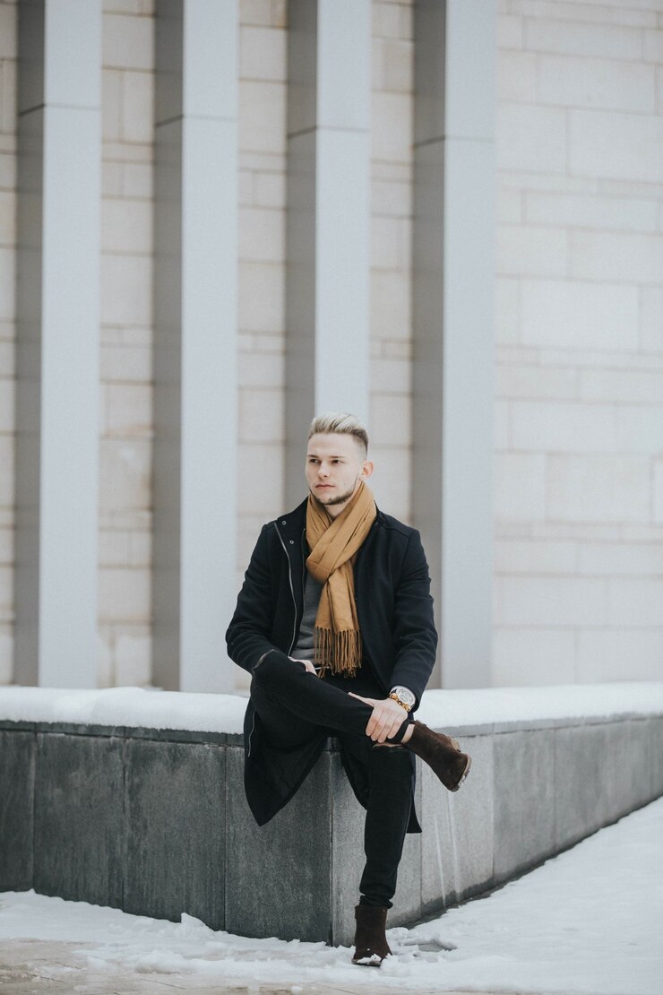 Foto grátis foto vertical de um homem caucasiano elegante posando ao ar livre em uma cidade com neve