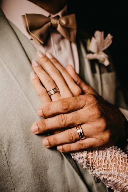 Foto vertical de um homem segurando a mão da mulher no peito