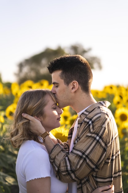 Foto grátis foto vertical de um lindo casal caucasiano no campo de girassóis na espanha