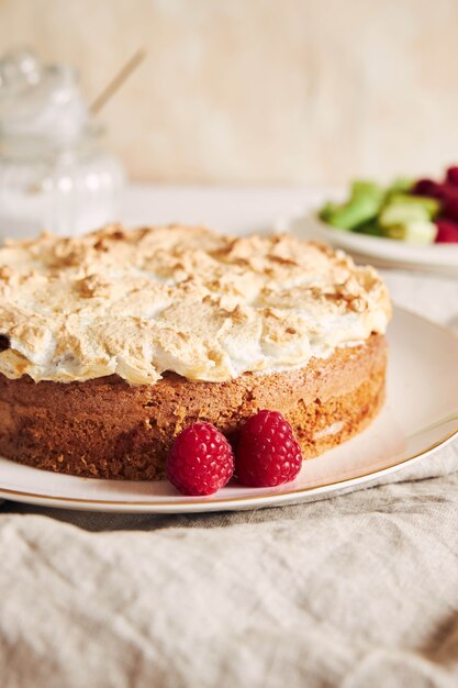 Foto vertical de um lindo e delicioso bolo de framboesa e ruibarbo com ingredientes em uma mesa