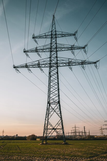 Foto vertical de um poste elétrico sob um céu azul nublado