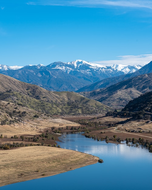 Foto grátis foto vertical de um rio sinuoso com montanhas majestosas e céu azul