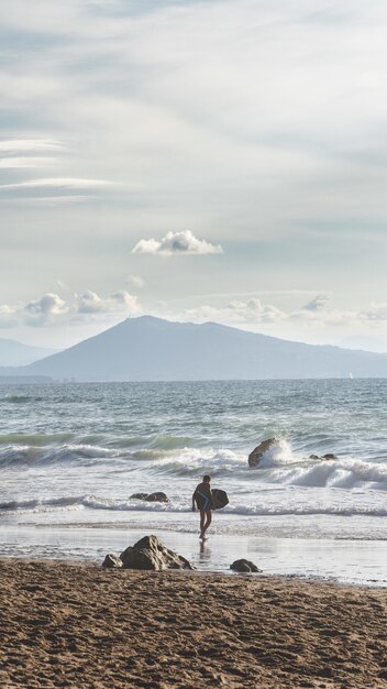 Foto vertical de um surfista solitário em um mar