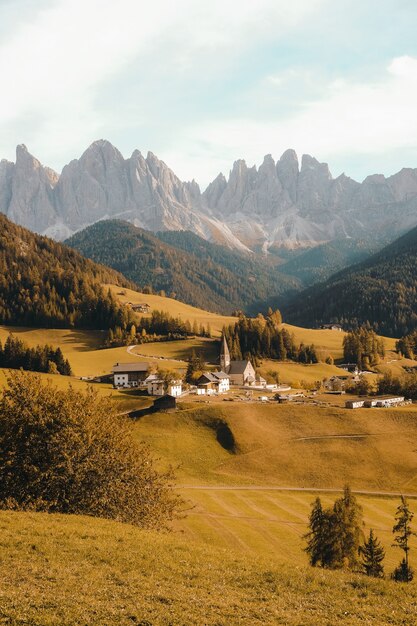 Foto vertical de uma bela vila em uma colina cercada por montanhas