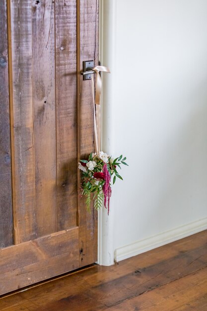 Foto vertical de uma decoração de flores pendurada na maçaneta da porta