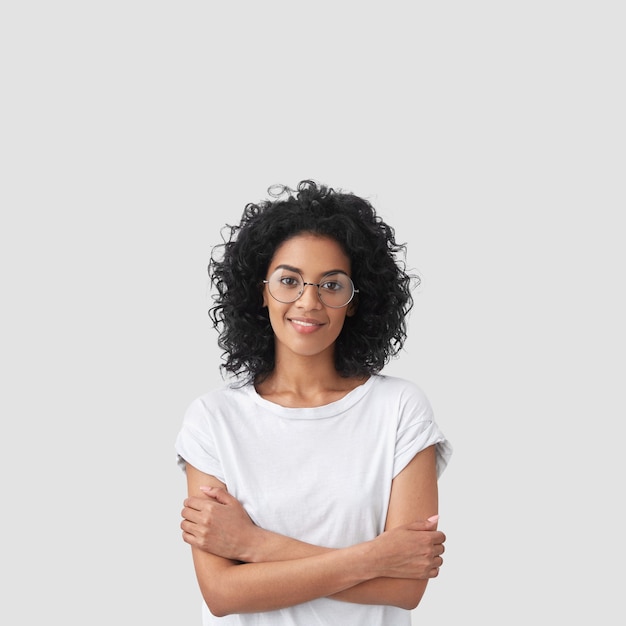 Foto grátis foto vertical de uma feliz mulher de pele escura com cabelo encaracolado