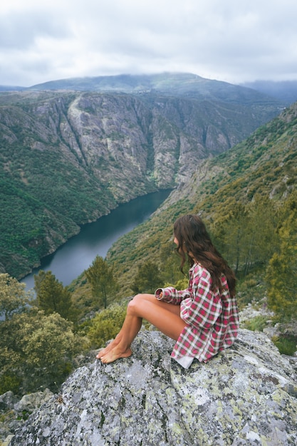 Foto vertical de uma jovem mulher branca em Sil Canyon, na Espanha