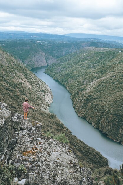 Foto vertical de uma jovem no Sil Canyon, na Espanha