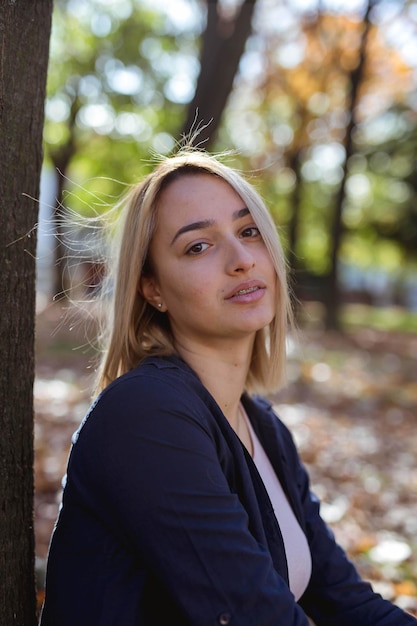 Foto vertical de uma linda mulher caucasiana posando no parque