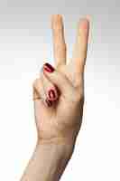 Foto grátis foto vertical de uma mão feminina com um sinal da paz