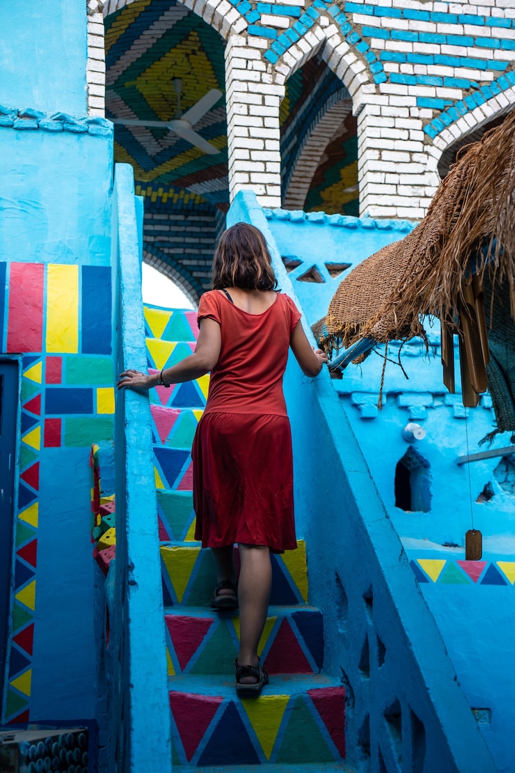 Foto grátis foto vertical de uma mulher caucasiana subindo as escadas na tradicional casa azul