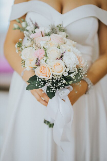 Foto vertical de uma noiva com um buquê