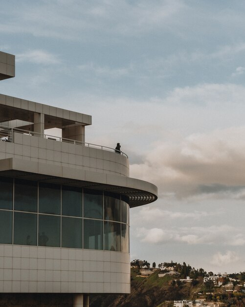 Foto vertical de uma pessoa em pé no topo de um edifício